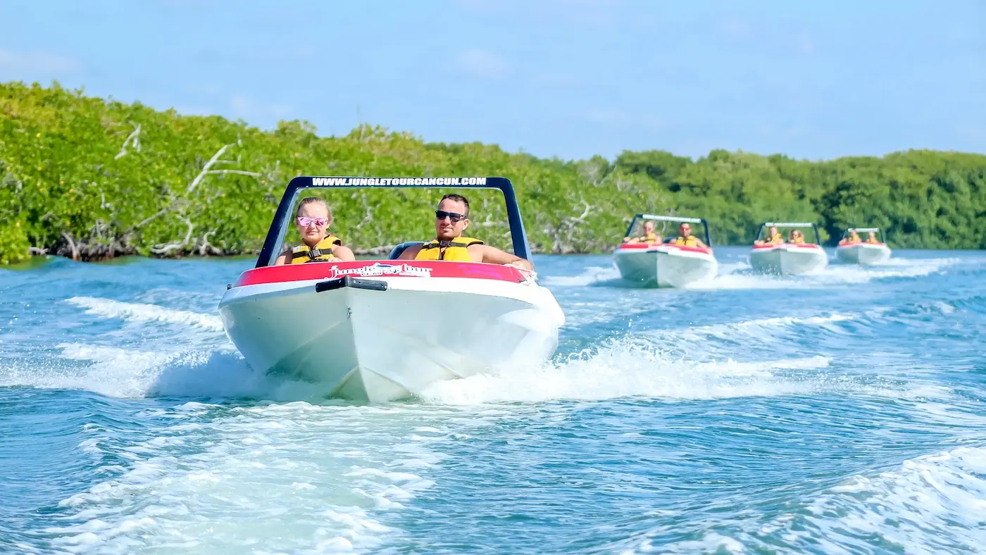 a caravan of three jungle tour adventure speedboats sailing through the mangrove canals in Cancun