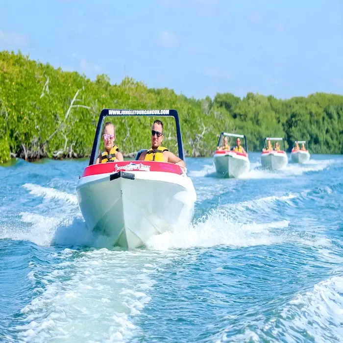 a caravan of three jungle tour adventure speedboats sailing through the mangrove canals in Cancun